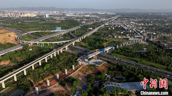 航拍正在建設(shè)的跨越成都繞城高速公路連續(xù)梁施工現(xiàn)場，旁邊依次為已運營的成渝高速鐵路和機場高速公路?！⒅铱?攝