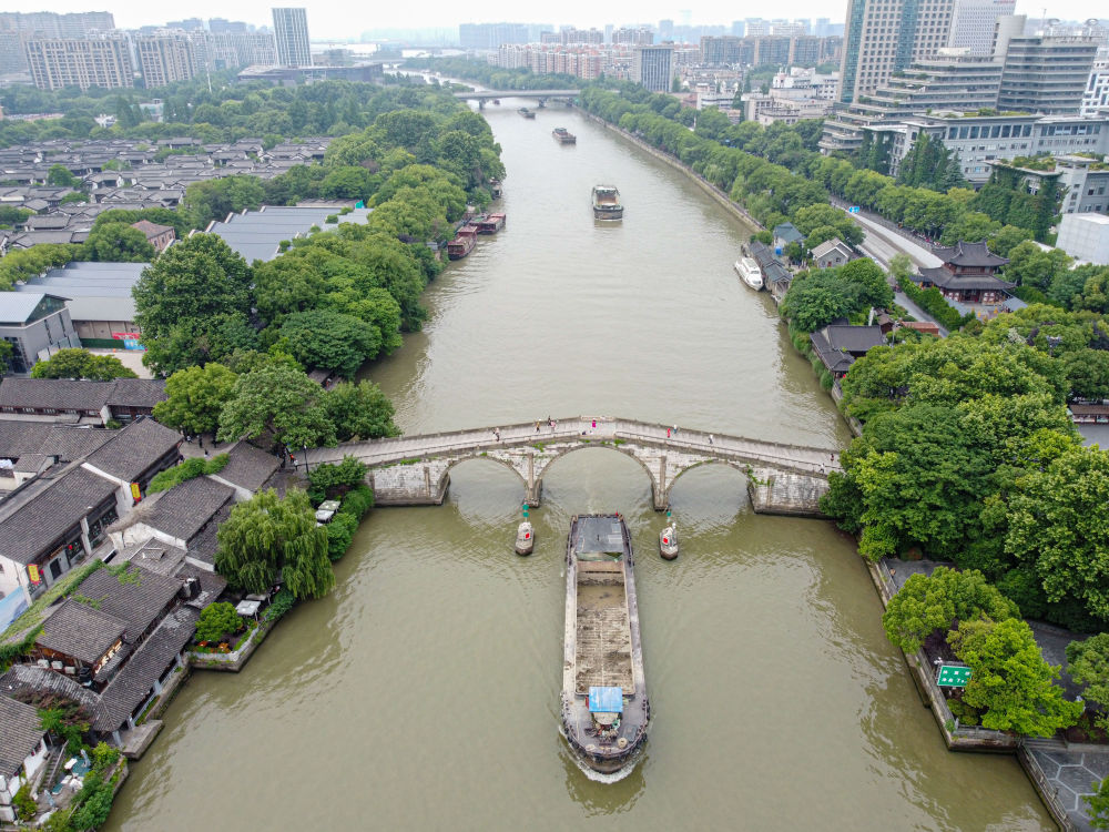 5月27日，一艘貨船駛過京杭大運(yùn)河南端標(biāo)志建筑杭州拱宸橋。(無人機(jī)照片)新華社記者江漢 攝