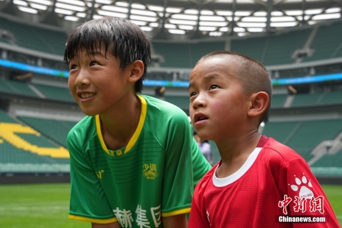 圖為北京國(guó)安小球員陳小北和7歲的俄金仁增在一起觀看場(chǎng)內(nèi)播放的紀(jì)錄片。<a target='_blank' href='/' _fcksavedurl='/'><p  align=