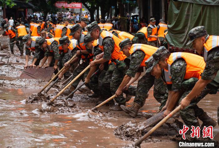 7月4日，萬州區(qū)五橋街道，武警官兵清理街道上的淤泥。　冉孟軍 攝