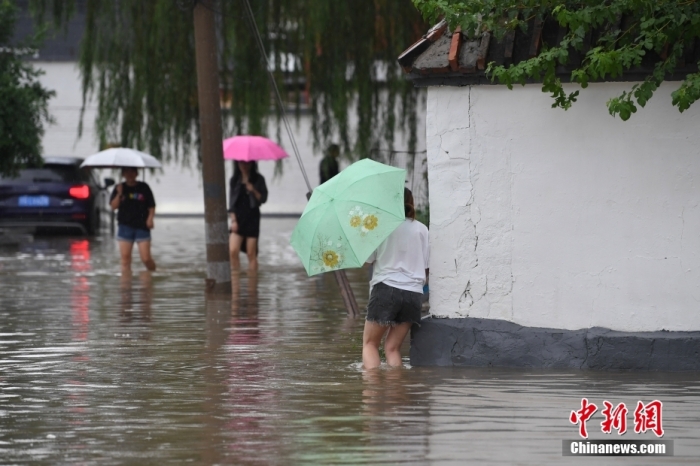 7月31日，市民行走在雨中的北京房山區(qū)瓦窯頭村。北京市氣象臺當日10時發(fā)布分區(qū)域暴雨紅色預警信號。北京市水文總站發(fā)布洪水紅色預警，預計當日12時至14時，房山區(qū)大石河流域將出現(xiàn)紅色預警標準洪水。<a target='_blank' href='/'><p  align=