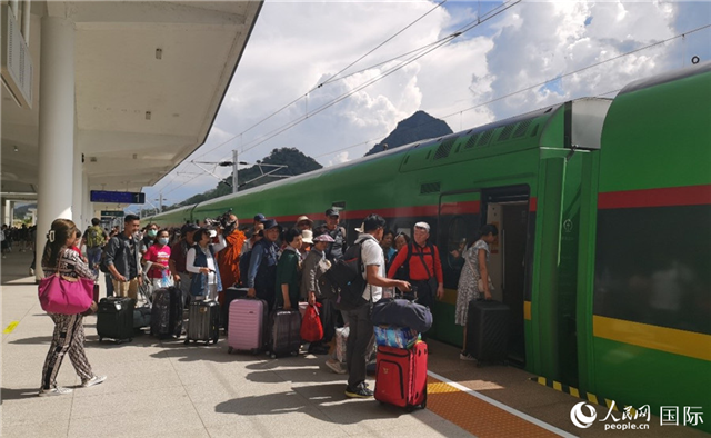 乘坐中老鐵路國(guó)際旅客列車的旅客在老撾瑯勃拉邦站排隊(duì)上車。人民網(wǎng)記者 杜明明攝