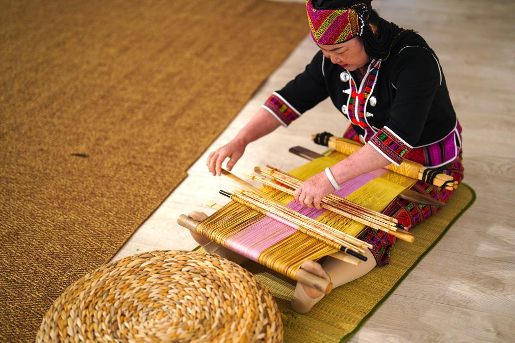 4月17日，黎族傳統(tǒng)紡染織繡技藝國(guó)家級(jí)代表性傳承人劉香蘭在2023年意大利米蘭設(shè)計(jì)周上展示黎錦織造技藝。新華社發(fā)