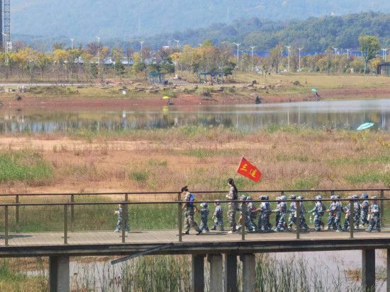 　　10月24日，秋游的幼兒園小朋友在老師帶領(lǐng)下走在清水塘公園里的木橋上。本報(bào)記者 常雯宜攝