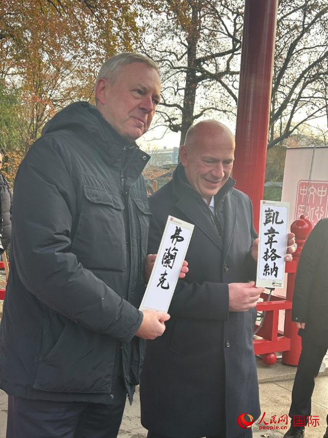 柏林市長韋格納（右）、動物園監(jiān)事會主席布魯克曼（左）手持中國文化中心工作人員現(xiàn)場手書的中文名字。人民網(wǎng)記者 徐馨攝