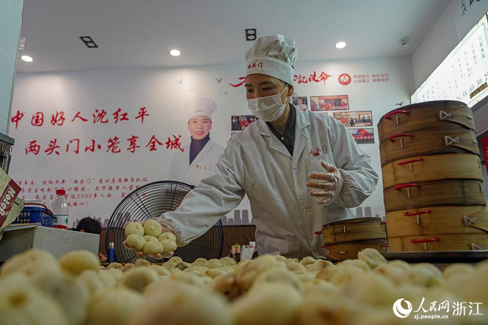 3月31日，在浙江省嵊州市甘霖鎮(zhèn)，嵊州小吃從業(yè)者沈紅平把蒸熟的小籠包晾涼，打包冷藏售賣。人民網(wǎng) 章勇濤攝