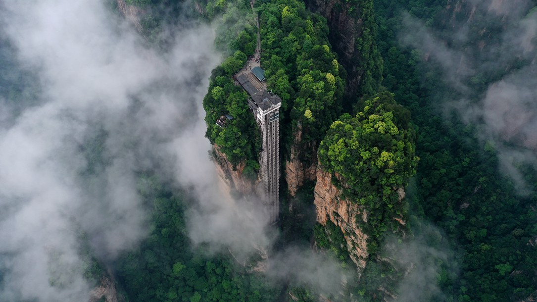 位于張家界武陵源景區(qū)的百龍?zhí)焯蓁偳对谠旗F繚繞的峰林間，雄偉壯觀。吳勇兵攝