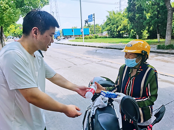 何超為過路的老人送上礦泉水和冷飲。人民網(wǎng)記者 王繼亮攝