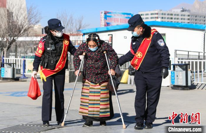 圖為拉薩鐵路公安民警幫助老人進站乘車?！『铲i 攝