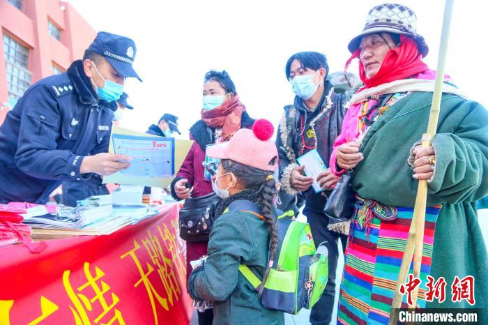 圖為拉薩鐵路公安民警向旅客發(fā)放乘車安全宣傳資料。　黃飛 攝