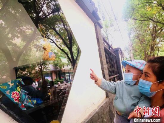 圖為蘭州市民在街頭觀賞刺繡和刻葫蘆的非遺展示。(資料圖) 史靜靜 攝