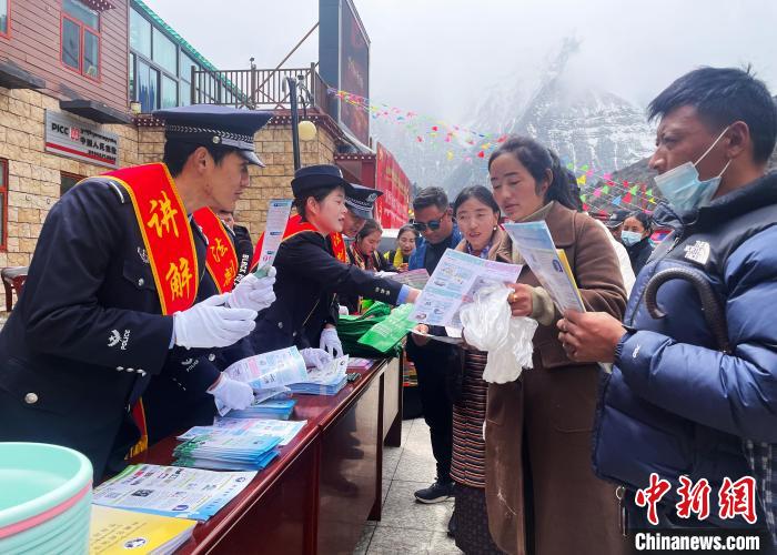 圖為山南玉麥邊境派出所民警為轄區(qū)群眾發(fā)放法律知識(shí)宣傳單?！＄婗?　攝