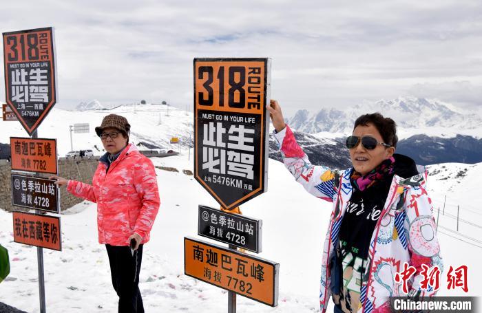 圖為5月14日，西藏林芝色季拉山觀景臺(tái)，游客與南迦巴瓦峰合影?！±盍?攝