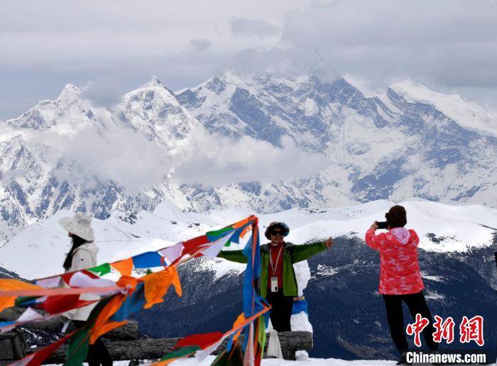 圖為5月14日，西藏林芝色季拉山觀景臺(tái)，游客與南迦巴瓦峰合影?！±盍?攝