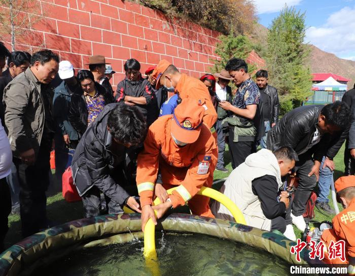 圖為森林消防員為護(hù)林員講解滅火裝備的使用方法。　昌都市森林消防支隊(duì) 供圖