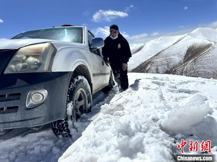 圖為生態(tài)管護人員準備在雪地推車?！《“瓦_杰 攝