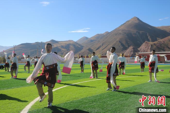 圖為青海師范大學(xué)附屬玉樹實驗學(xué)校學(xué)生在綠茵場跳起囊謙古舞—卓根瑪?！〕逃?攝