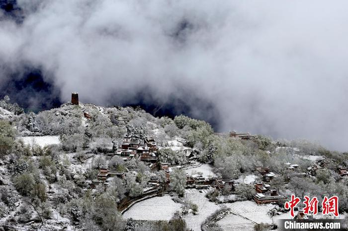 雪后的藏寨和碉樓構(gòu)成美麗的雪景?！〗党鯘衫?攝