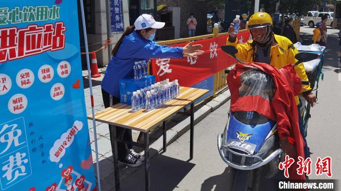 圖為近日，西藏自治區(qū)青年志愿者協(xié)會志愿者在拉薩街頭向快遞員送水。西藏自治區(qū)青年志愿者協(xié)會 供圖