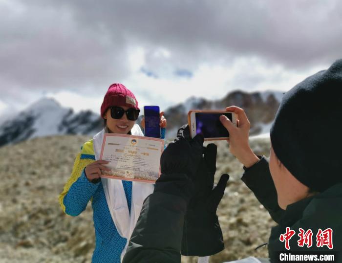 圖為5日，登頂洛堆峰的登山者獲得西藏自治區(qū)登山協(xié)會頒發(fā)的登頂證明。　張偉 攝