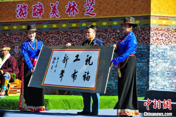 圖為14日，當(dāng)?shù)孛癖娛謱?xiě)工布新年賀詞?！垈?攝