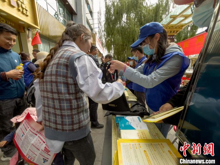 圖為志愿者為市民發(fā)放網(wǎng)絡(luò)安全宣傳手冊(cè)?！≈x牧 攝