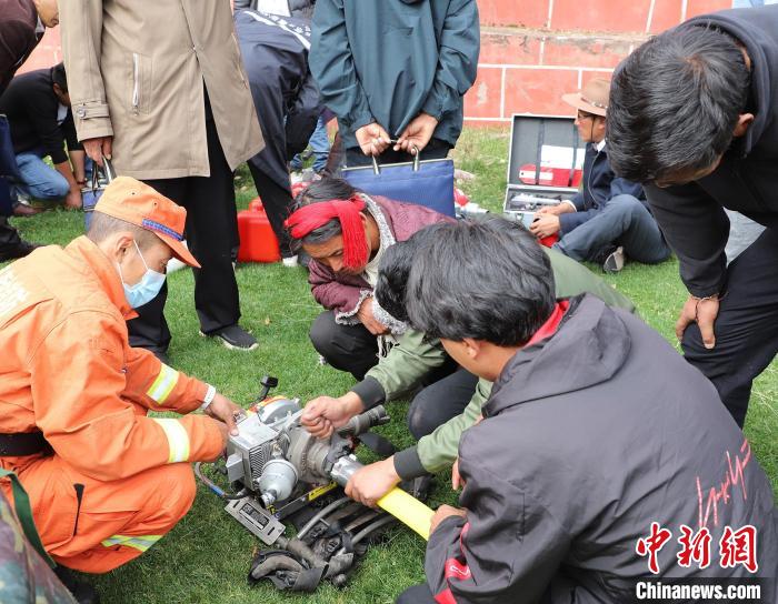 圖為森林消防員為護林員講解滅火裝備的使用方法?！〔际猩窒乐ш?供圖