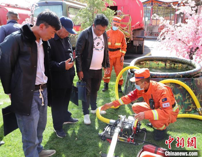 圖為森林消防員為護林員講解滅火裝備的使用方法?！〔际猩窒乐ш?供圖