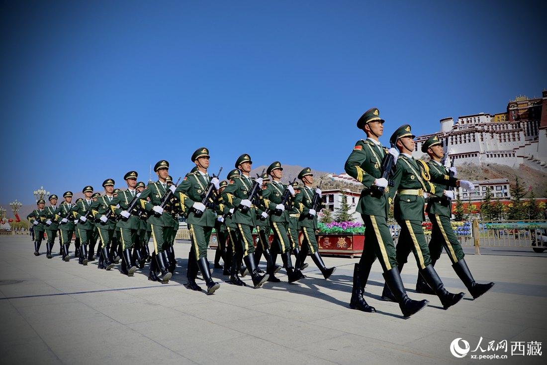 國旗護衛(wèi)隊隊員緊握鋼槍，踏著威武雄壯的步伐，走向國旗臺。人民網(wǎng) 次仁羅布攝