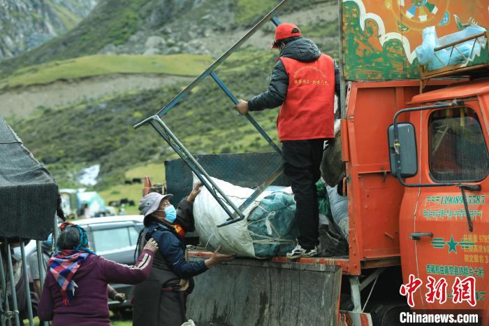 圖為工作人員幫助牧民們卸家具?！÷蹇?攝