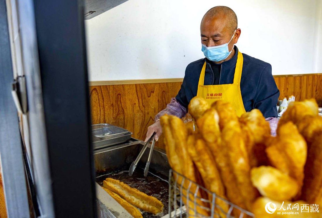 早餐店老板正在炸油條。人民網(wǎng) 次仁羅布攝