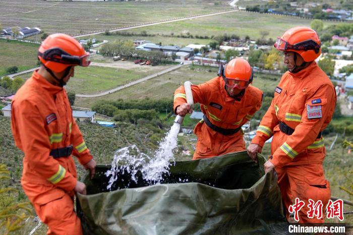 技能大練兵過(guò)程中，消防員在陡坡上向蓄水池注水?！±顕?guó)燾 攝