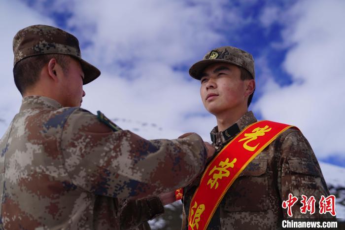 排長王朝偉(圖左)給退伍老兵佩戴大紅花。　西藏山南軍分區(qū)某團(tuán)供圖