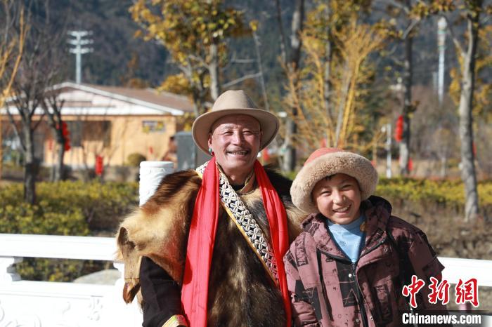 圖為林芝市巴宜區(qū)布久鄉(xiāng)仲果村村民桑杰與孫子一起參加藏歷新年活動(dòng)?！埩?攝