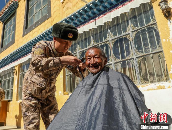 圖為阿里軍分區(qū)某邊防團(tuán)官兵為駐地群眾理發(fā)迎藏歷新年。　旦增倫珠 攝