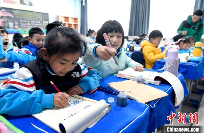 3月14日，西藏拉薩市第一小學(xué)一年級六班學(xué)生白瑪朗珍(圖左)在藏語文課上書寫藏文?！±盍?攝