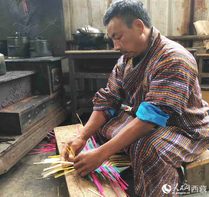 門巴族漢子愛明正在編織藤竹品。