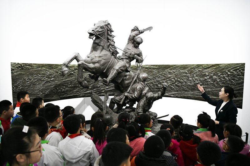 2019年4月4日，在東北烈士紀(jì)念館，學(xué)生們?cè)诼?tīng)講解員講解。