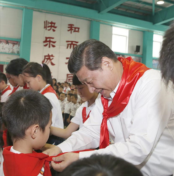 2014年5月30日，在北京市海淀區(qū)民族小學(xué)的少先隊(duì)入隊(duì)儀式上，習(xí)近平為新少先隊(duì)員系上紅領(lǐng)巾。