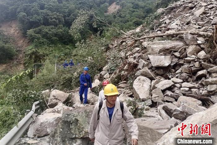 電力搶險(xiǎn)人員徒步通過垮塌路段。　四川電力供圖