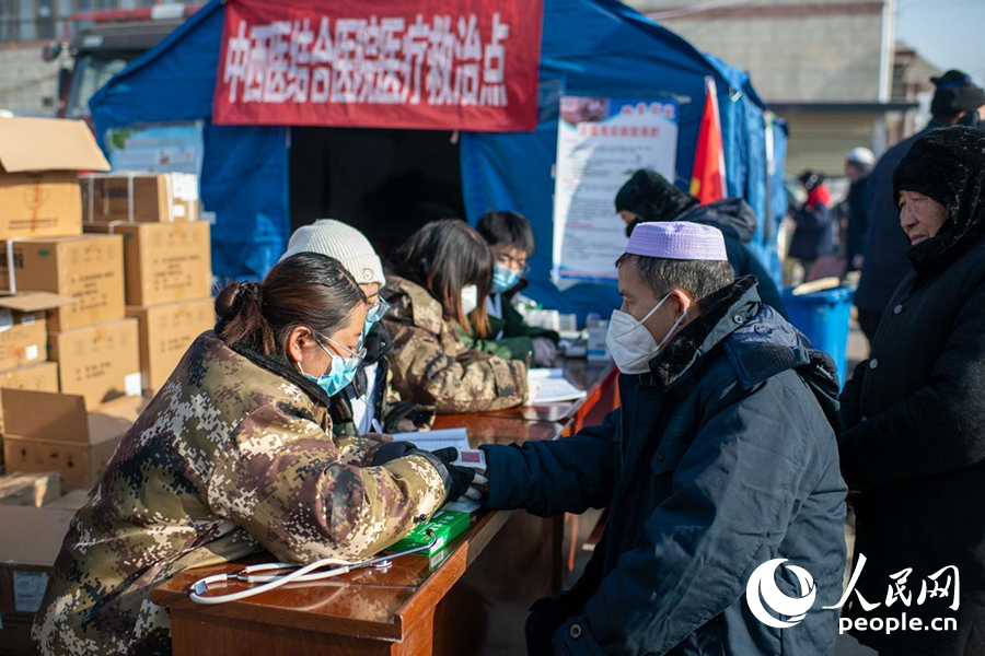 12月22日，在積石山縣大河家鎮(zhèn)大河村安置點的醫(yī)療救治點，醫(yī)生正在為群眾進(jìn)行醫(yī)療問診。人民網(wǎng)記者 翁奇羽攝