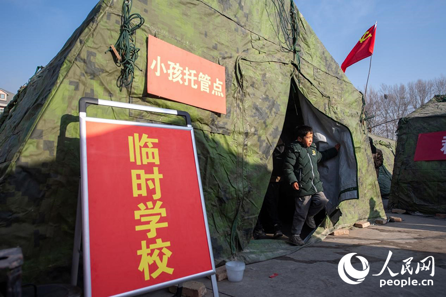 12月22日，在積石山縣大河家鎮(zhèn)大河村安置點，陸軍76集團(tuán)軍某旅搭建的“臨時學(xué)?！背蔀樾∨笥训摹凹佑驼尽?。人民網(wǎng)記者 翁奇羽攝