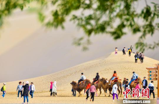 甘肅敦煌開(kāi)啟旅游旺季數(shù)萬(wàn)人“五一”暢游鳴沙山